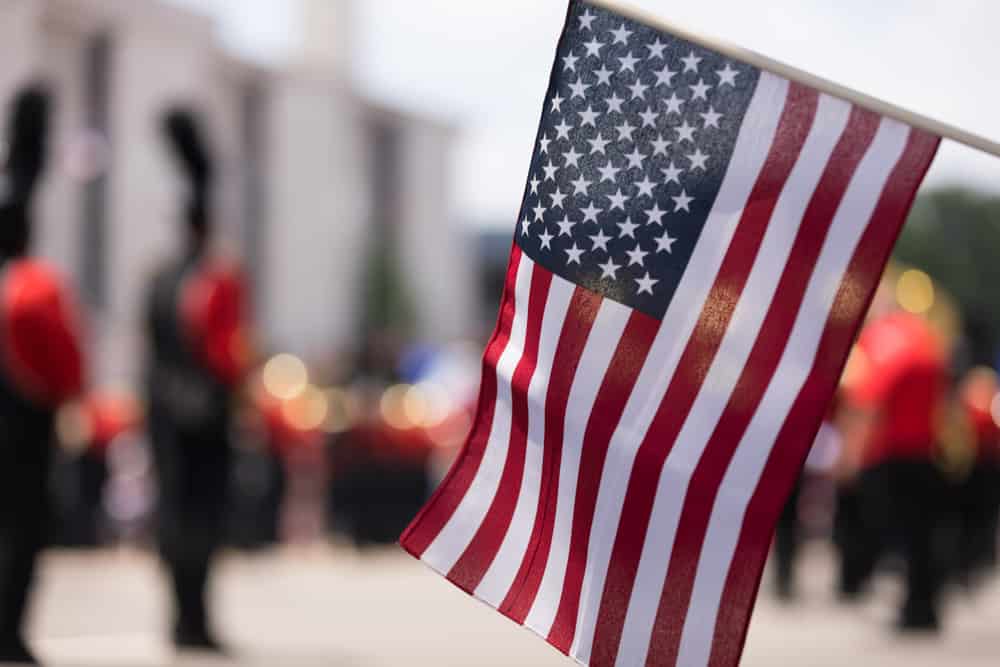 American flag hanging in front of a blurred marching band