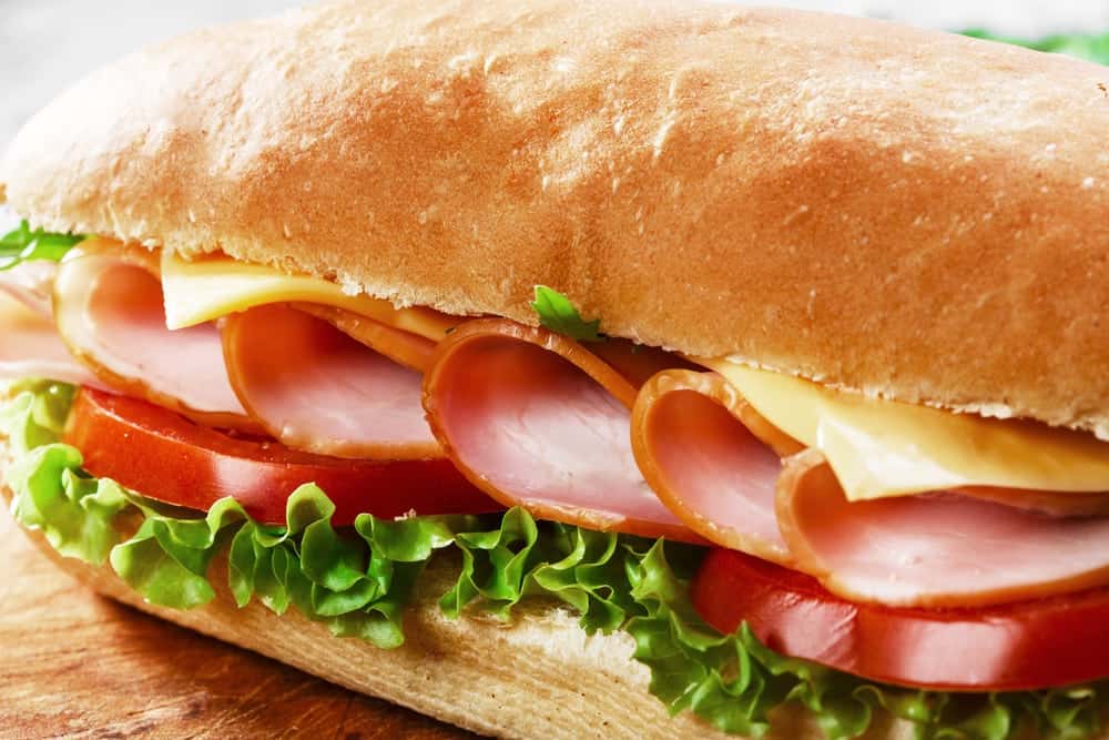Tasty ham and cheese sub with lettuce and tomato.