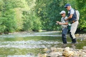farther and son trout fishing in the river